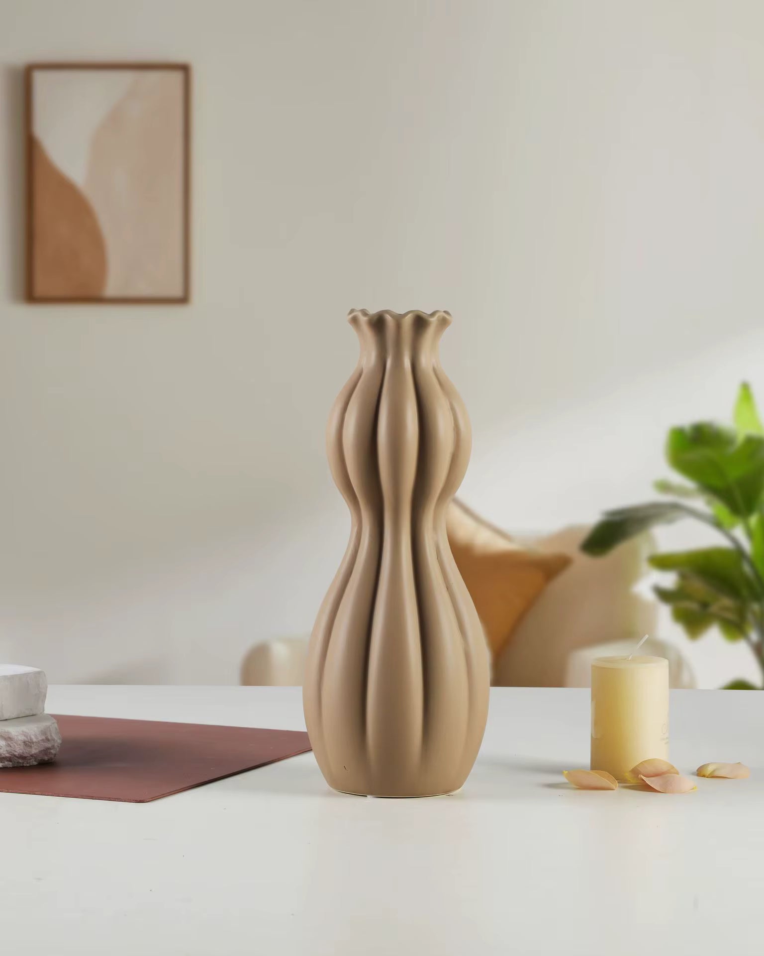 Beige ceramic vase on a white surface with a blurred background