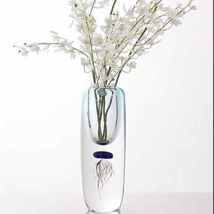 Clear glass vase with a jellyfish design and white flowers on a white background