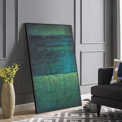Abstract painting leaning against a wall in a living room setting.