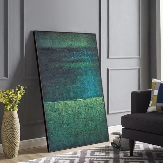 Abstract painting leaning against a wall in a living room setting.
