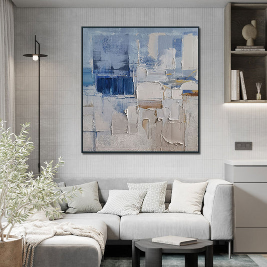 Modern living room with a gray sofa, abstract painting, and decorative elements.