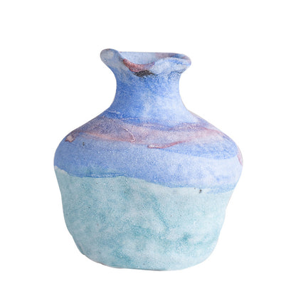 Ceramic vase with blue and pink marbled pattern on a white background