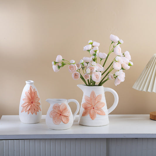 Set of white ceramic vases with floral designs on a beige background