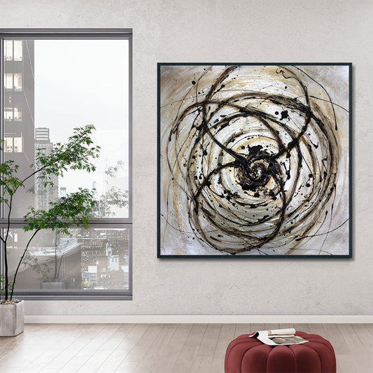 Abstract art piece on a wall with a cityscape view through a window.