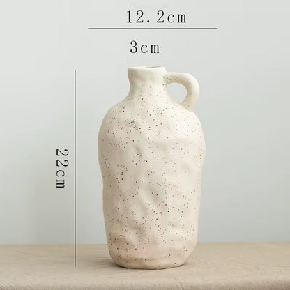 Speckled ceramic vase on a neutral background with measurements indicated.