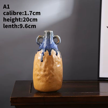 Ceramic vase with blue top and brown base on a dark surface with a gray background