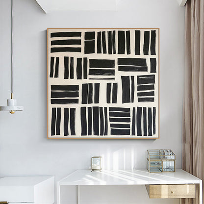 Abstract black and white artwork on a wall above a white desk.