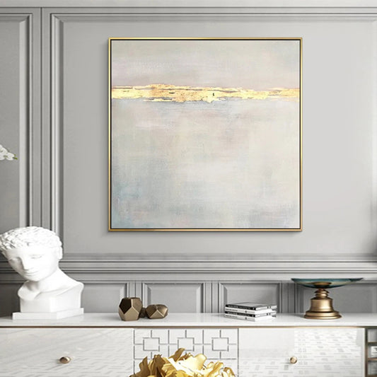 Abstract painting with gold accents on a wall above a white console table.