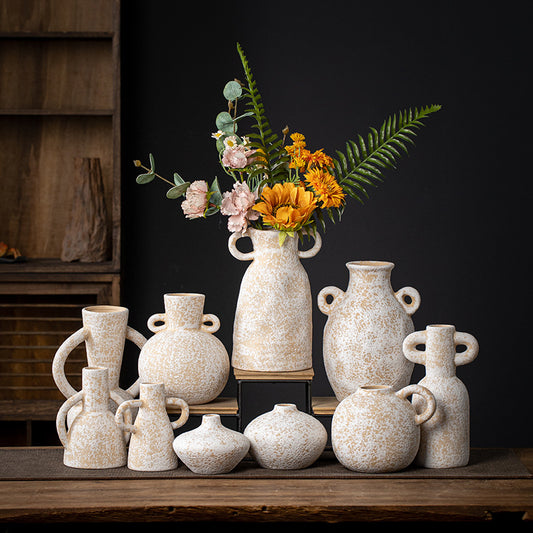 Collection of ceramic vases on a wooden surface with a dark background