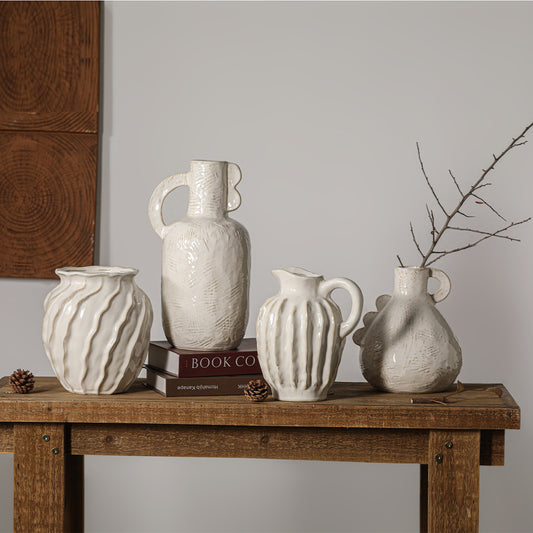 Set of four ceramic vases on a wooden table with a neutral background