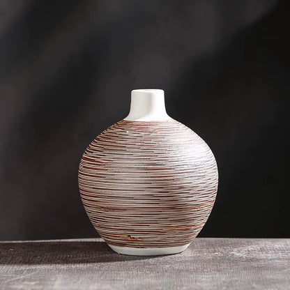Decorative vase with brown and white striped pattern on a dark background