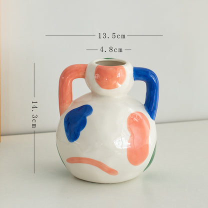 Ceramic vase with colorful abstract design and measurements on a white background