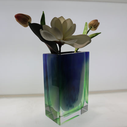 Colorful glass vase with flowers on a white background