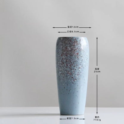 Blue speckled vase with measurements on a gray background