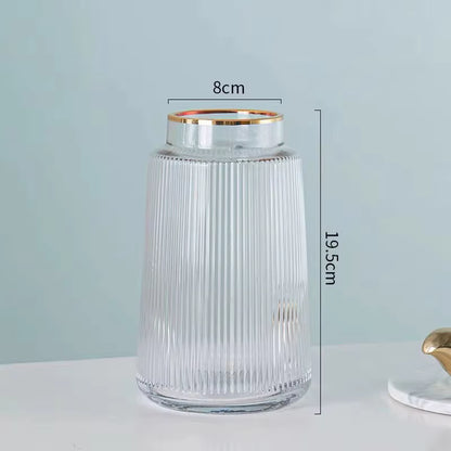 Clear glass jar with gold rim and measurements on a light gray background