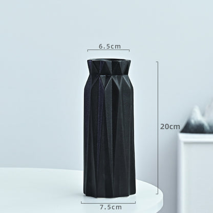 Black geometric vase with measurements on a light gray background