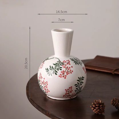 White vase with floral patterns on a wooden surface, with measurements indicated.