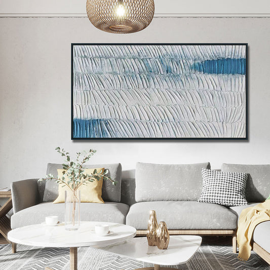 Living room with a gray sofa, coffee table, and abstract art on the wall.
