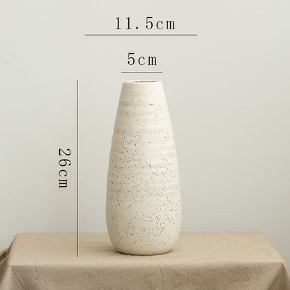 White textured vase on a beige surface with measurements indicated.