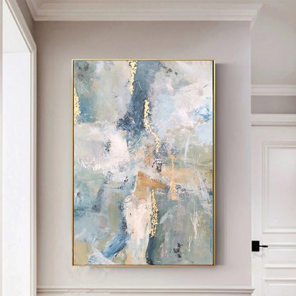 Abstract painting with gold accents on a wall in a room with white walls and a door.
