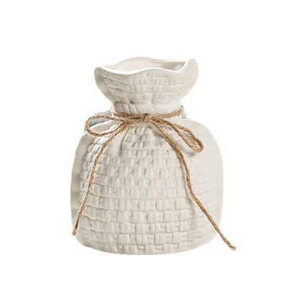 White textured vase with a string bow on a white background