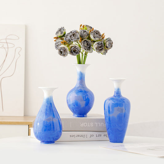Three blue vases with marbled patterns on a white surface.