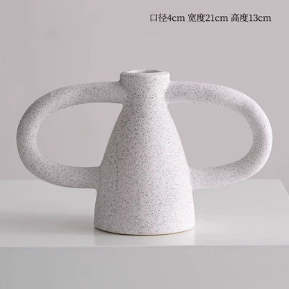 Speckled gray ceramic vase with two handles on a light gray background
