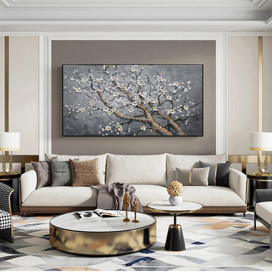 Modern living room with a large painting of floral branches on the wall above a beige sofa.