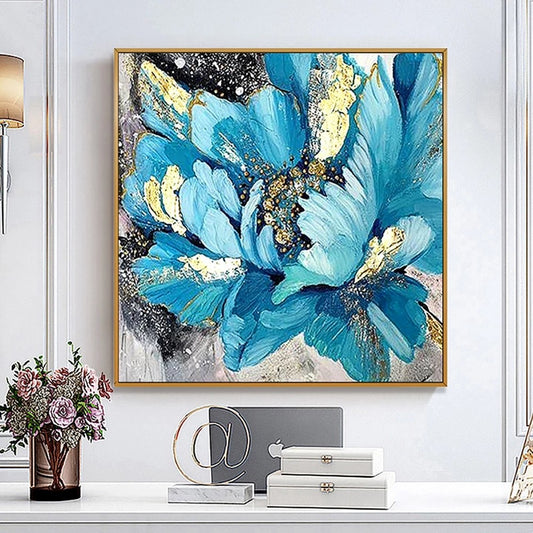 Abstract painting of blue flowers with gold accents on a wall above decorative items.