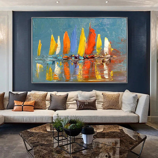 Living room with a large abstract painting of sailboats on a blue background, a beige sofa with decorative pillows, and a coffee table.