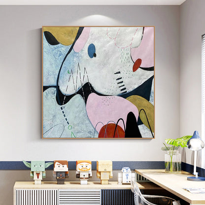 Abstract artwork on a wall above a desk with decorative items.