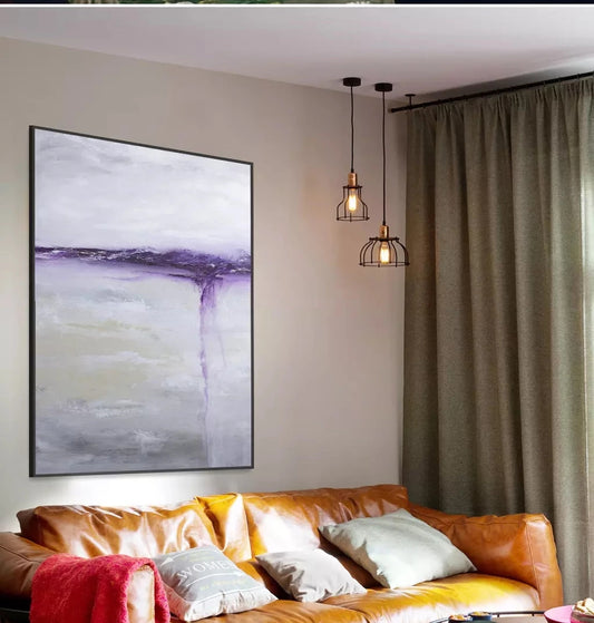Living room with a brown leather sofa, abstract painting, and pendant lights.