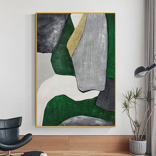 Abstract art piece with green, gray, and gold colors in a gold frame on a wall.