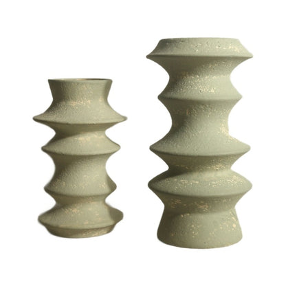 Two textured ceramic candle holders on a white background