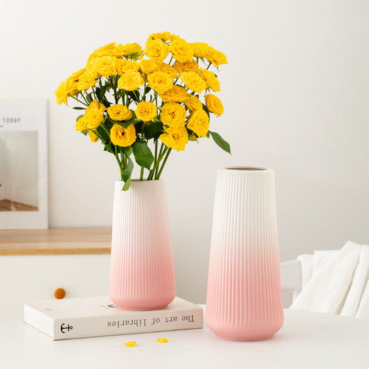 Pink textured vase with yellow flowers on a white surface