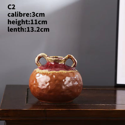 Ceramic vase with handles on a wooden surface against a gray background