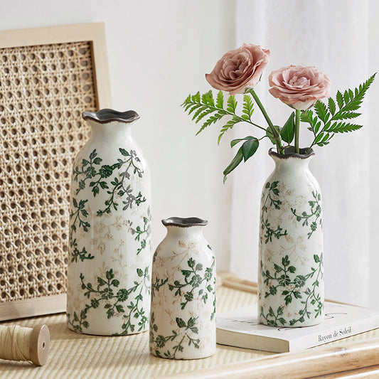 Set of three decorative vases with floral patterns on a table.