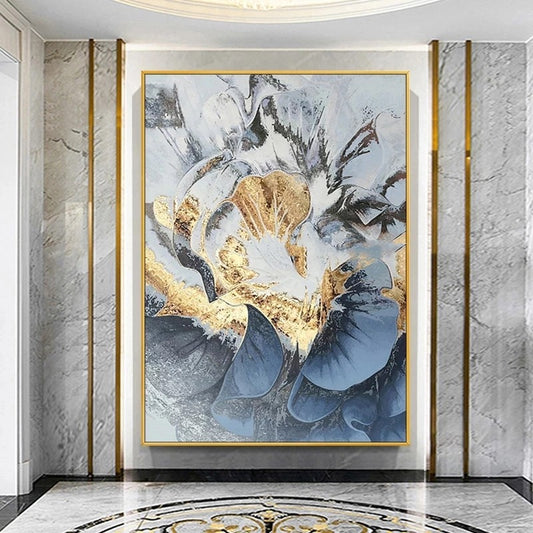 Abstract art piece with gold and blue tones in a gold frame on a marble wall.