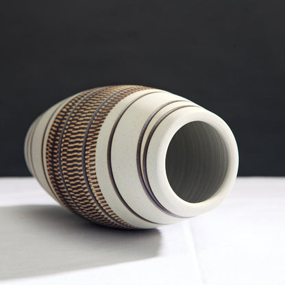 Ceramic vase with textured design on a black background