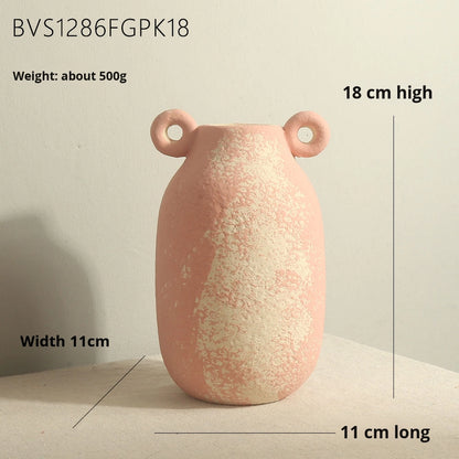 Pink ceramic vase with handles on a light surface, shown with measurements.