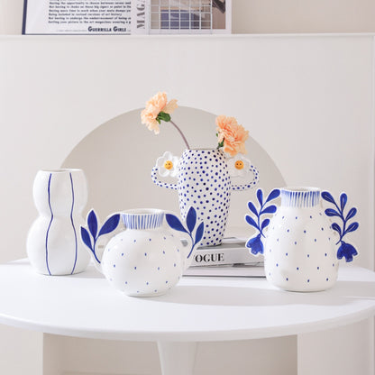 Set of white ceramic vases with blue patterns on a white surface