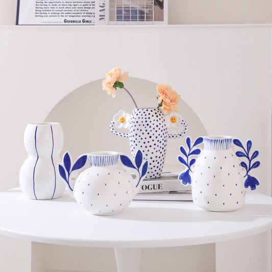 Set of white ceramic vases with blue patterns on a white surface
