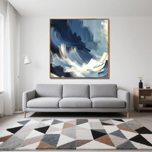 Gray sofa in a living room with a large abstract painting above it and a geometric rug on the floor.