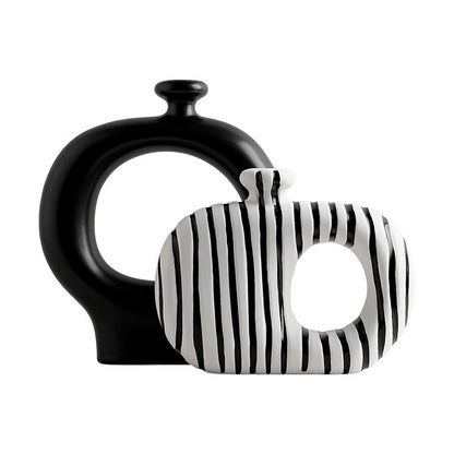 Black and white ceramic vase with striped pattern on a white background
