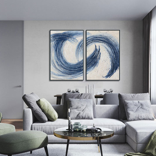 Modern living room with a gray sectional sofa, abstract blue artwork, and a round coffee table.