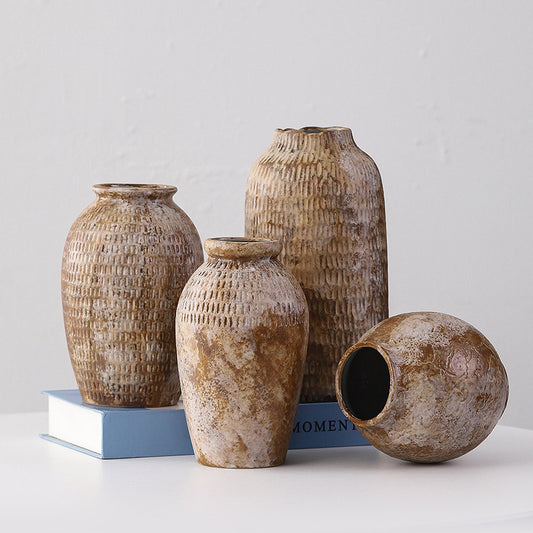 Set of four rustic ceramic vases on a light gray background