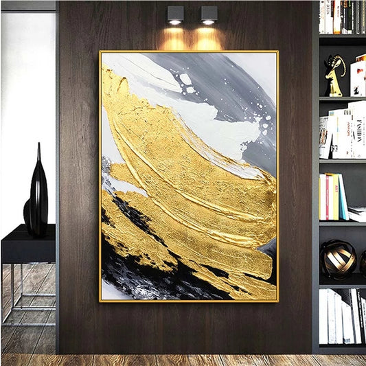 Abstract art piece with gold and black strokes on a wall in a room setting.