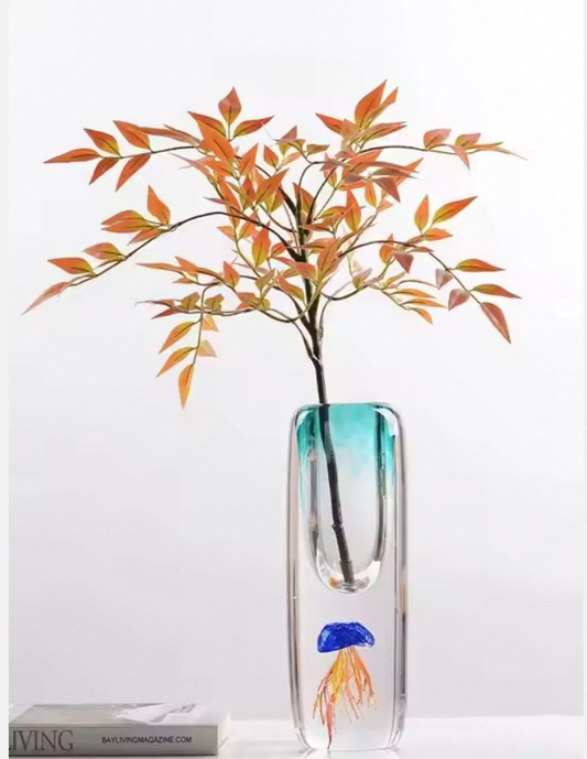 Glass vase with a plant on a white background