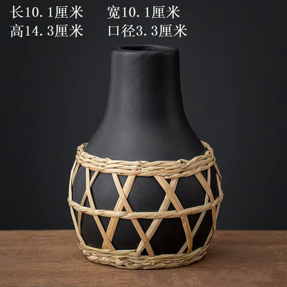 Black vase with woven basket design on a wooden surface and dark background