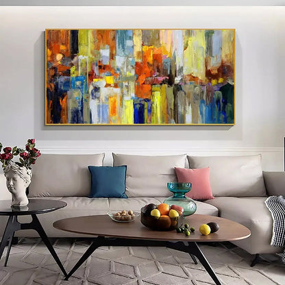 Living room with a large abstract painting above a sofa, coffee table with fruit, and decorative items.